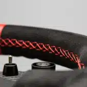Simagic GT1-R Alcantara grip close-up with red stitching detail and premium finish